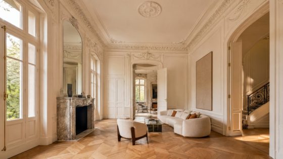 Salon d’une demeure ancienne : boiseries moulurées, corniche en staff, cheminée de marbre et parquet à bâtons rompus